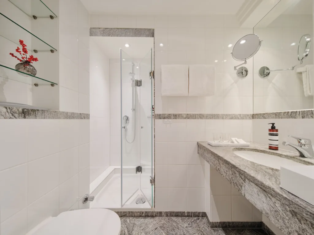 weiß-gefließtes-badezimmer-mit-dusche
