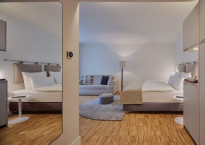 zimmer-mit-blick-auf-das-bett-und-der-couch-mit-beistelltisch