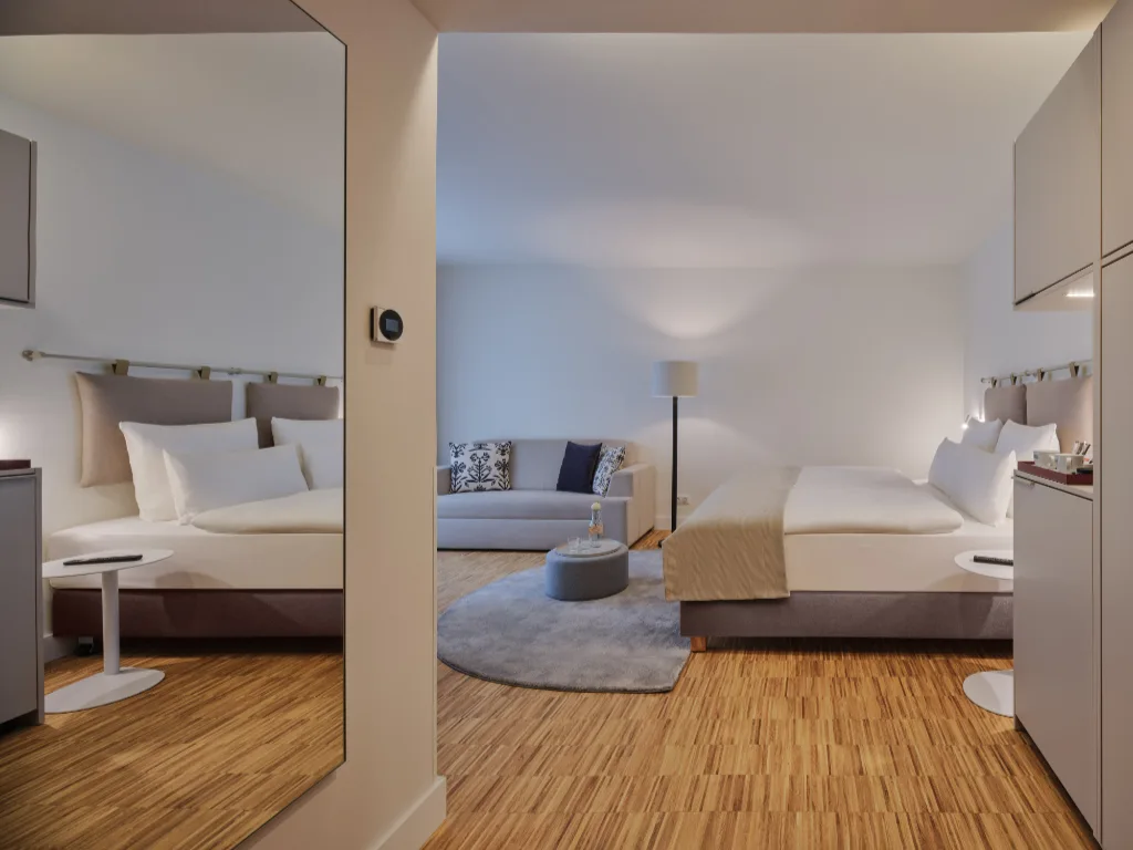 zimmer-mit-blick-auf-das-bett-und-der-couch-mit-beistelltisch