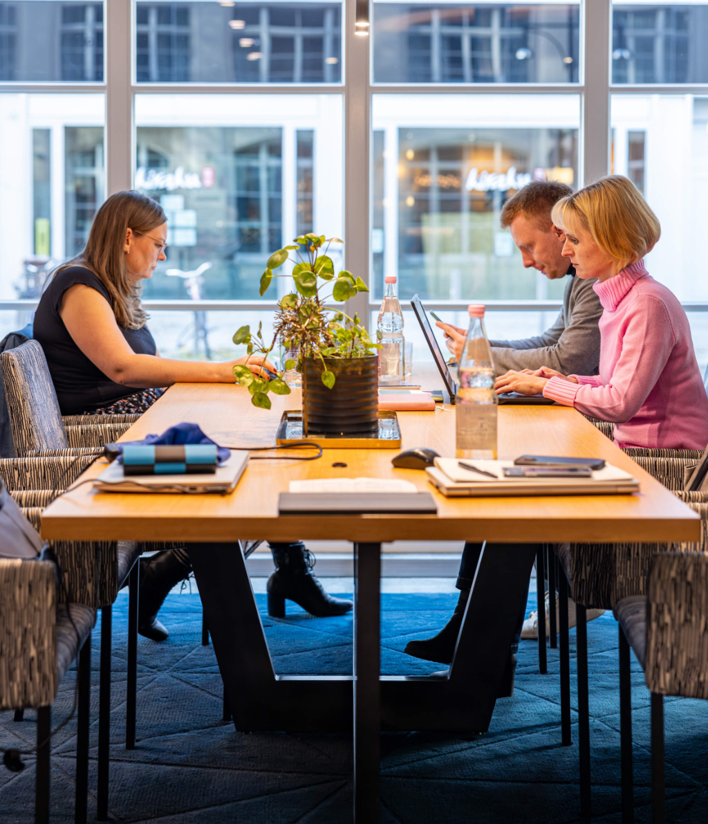 drei-personen-sitzen-arbeitend-am-laptop-am-tisch