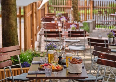 biergarten-mit-tischen-und-stuehlen-bretzelkorb-und-bier-information-öffnungszeiten
