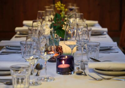gedeckte-tafel-weisse-tischdecke-weinglaeser-kerzen