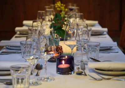 gedeckte-tafel-weisse-tischdecke-weinglaeser-kerzen