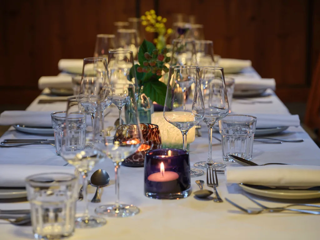 gedeckte-tafel-weisse-tischdecke-weinglaeser-kerzen