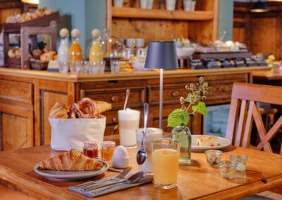 gedeckter-fruehstueckstisch-mit-croissant-orangensaft-und-latte-macchiato