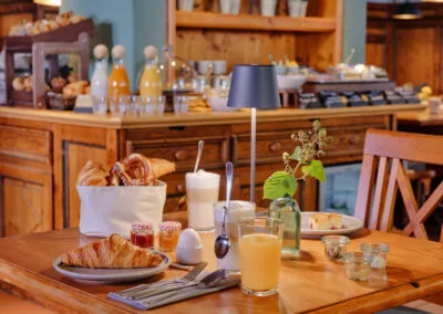 gedeckter-fruehstueckstisch-mit-croissant-orangensaft-und-latte-macchiato