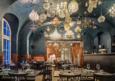 viele-verschiedene-kronleuchter-haengen-an-der-restaurantdecke