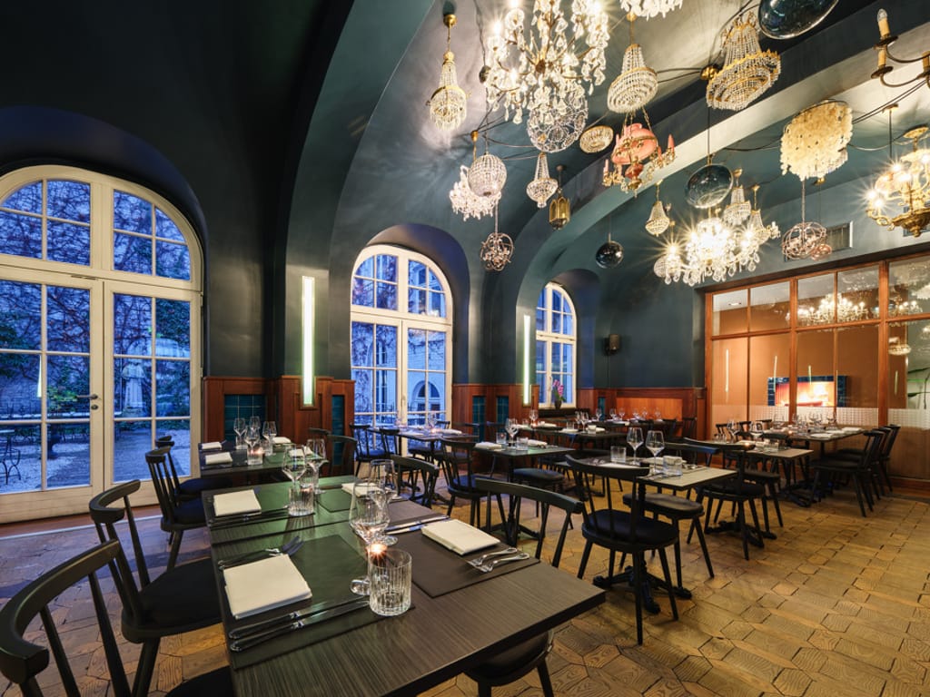 petrol-gestrichenes-restaurant-mit-vielen-kronleuchtern-an-der-decke