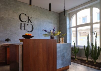rezeptionstresen-mit-großem-logo-des-hotels-im-hinterrund