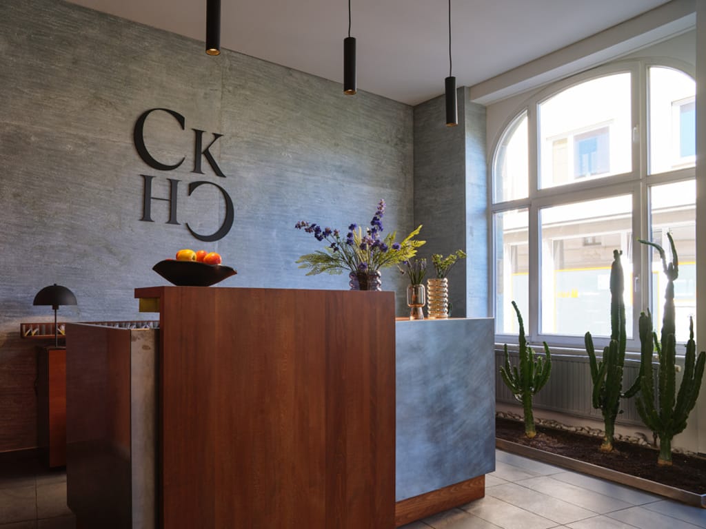 rezeptionstresen-mit-großem-logo-des-hotels-im-hinterrund