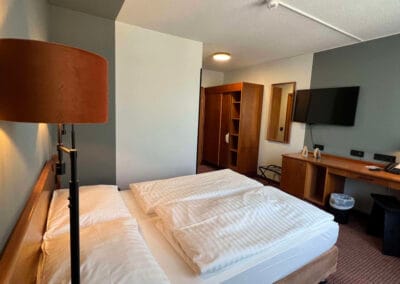 doppelbett-mit-stehleuchte-im-vordergrund