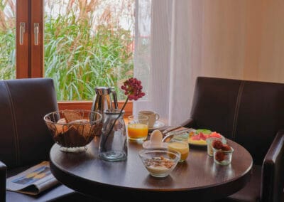 gedeckter-fruehstueckstisch-braune-sessel