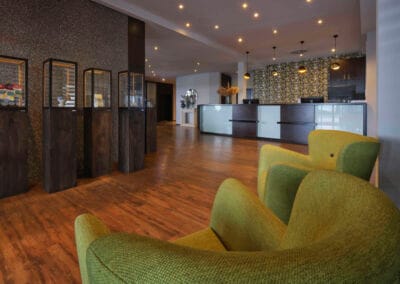 eingangsbereich-hotel-vitrinen-gruene-sessel