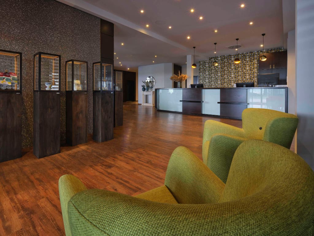 eingangsbereich-hotel-vitrinen-gruene-sessel