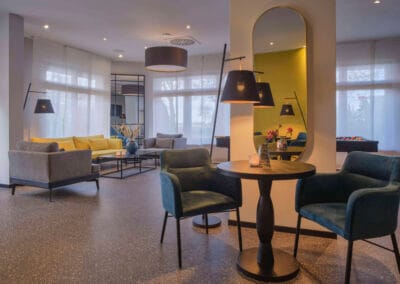 lobby-vordergrund-tisch-mit-stuehle-spiegel-hintergrund-sitzecke-mit-sofas