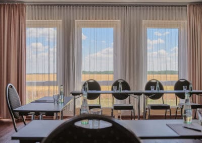 Tagungsraum-sicht-zu-bodentiefen-fenstern-feld-im-hintergrund