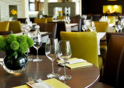 weinglaeser-auf-restauranttisch-gruene-servietten