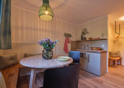 wohnbereich-kitchennette-runder-esstisch-sitzbank-stuehle