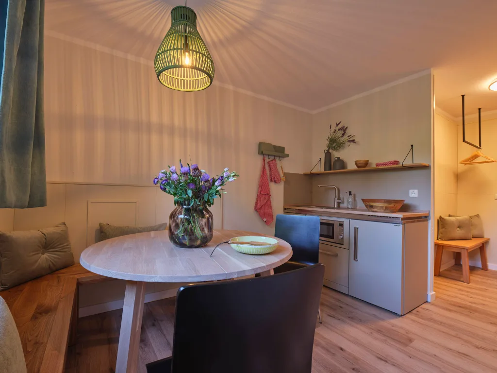 wohnbereich-kitchennette-runder-esstisch-sitzbank-stuehle