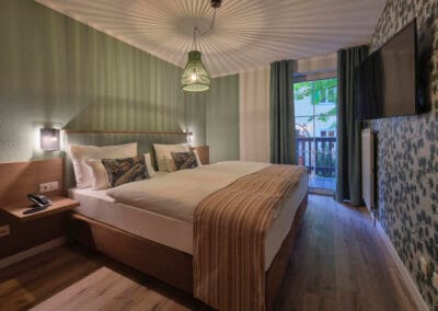 schlafzimmer-bodentiefe-fenster-doppelbett-tv