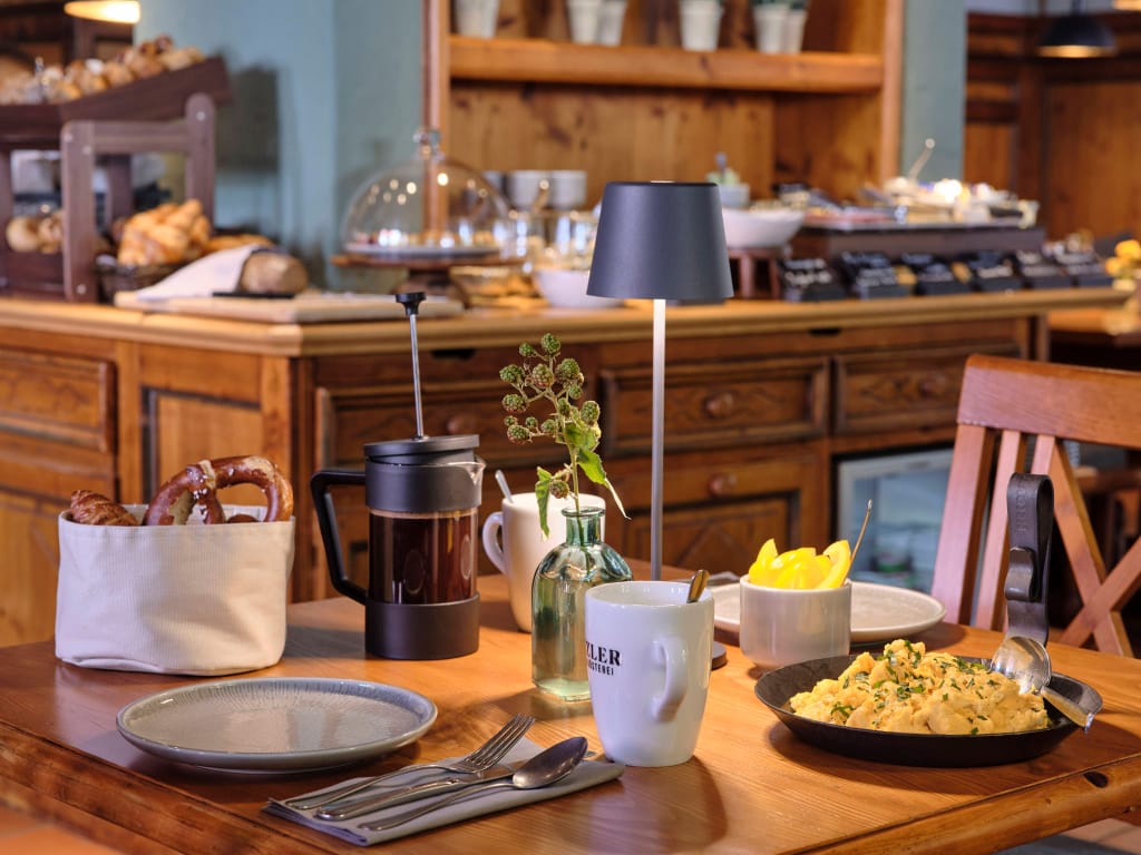 gedeckter-fruehstueckstisch-mit-ruehrei-bretzeln