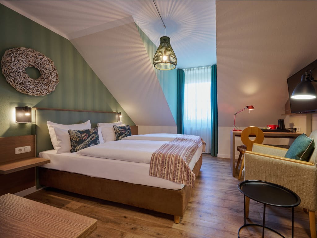 zimmer-mit-doppelbett-sessel-schreibtisch-deckenleuchte-schlaegt-muster-an-die-waende