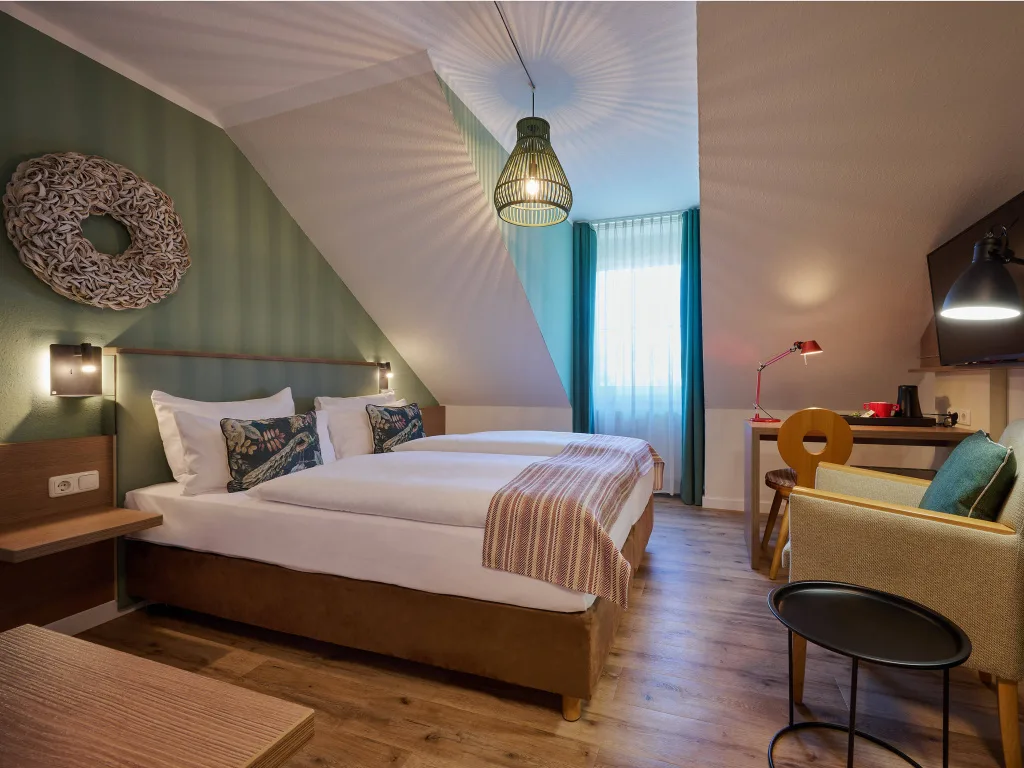 zimmer-mit-doppelbett-sessel-schreibtisch-deckenleuchte-schlaegt-muster-an-die-waende