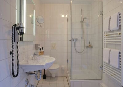 badezimmer-mit-dusche-weiss-gefliest