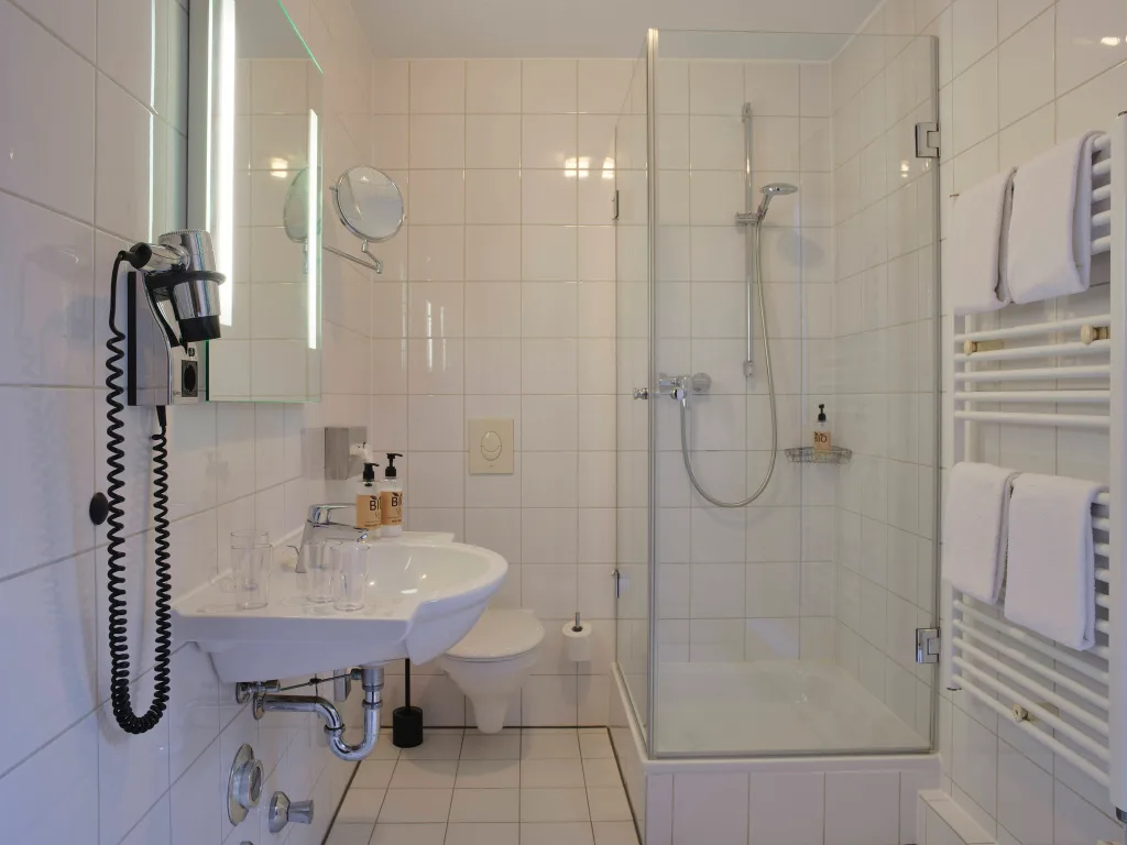 badezimmer-mit-dusche-weiss-gefliest