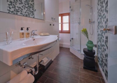 badezimmer-hell-gefließt-dunkler-laminatboden-dusche