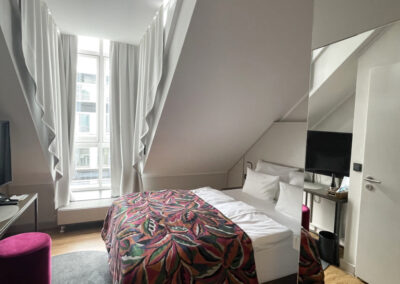 ansicht-classik-doppelzimmer-doppelbett-auffaelliger-rot-gemusterter-bettueberwurf