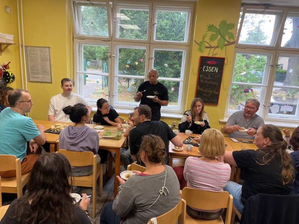 menschen sitzen am tisch und essen kuchen