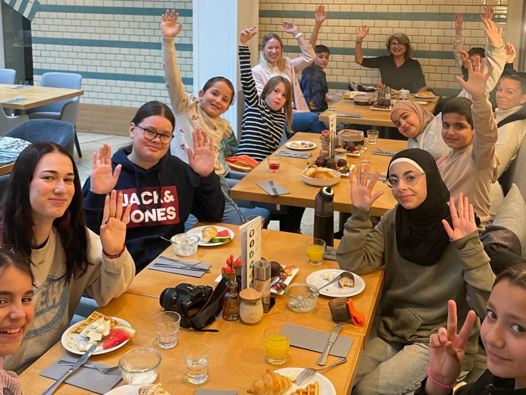 kinder sitzen am frühstückstisch und lächeln in die kamera