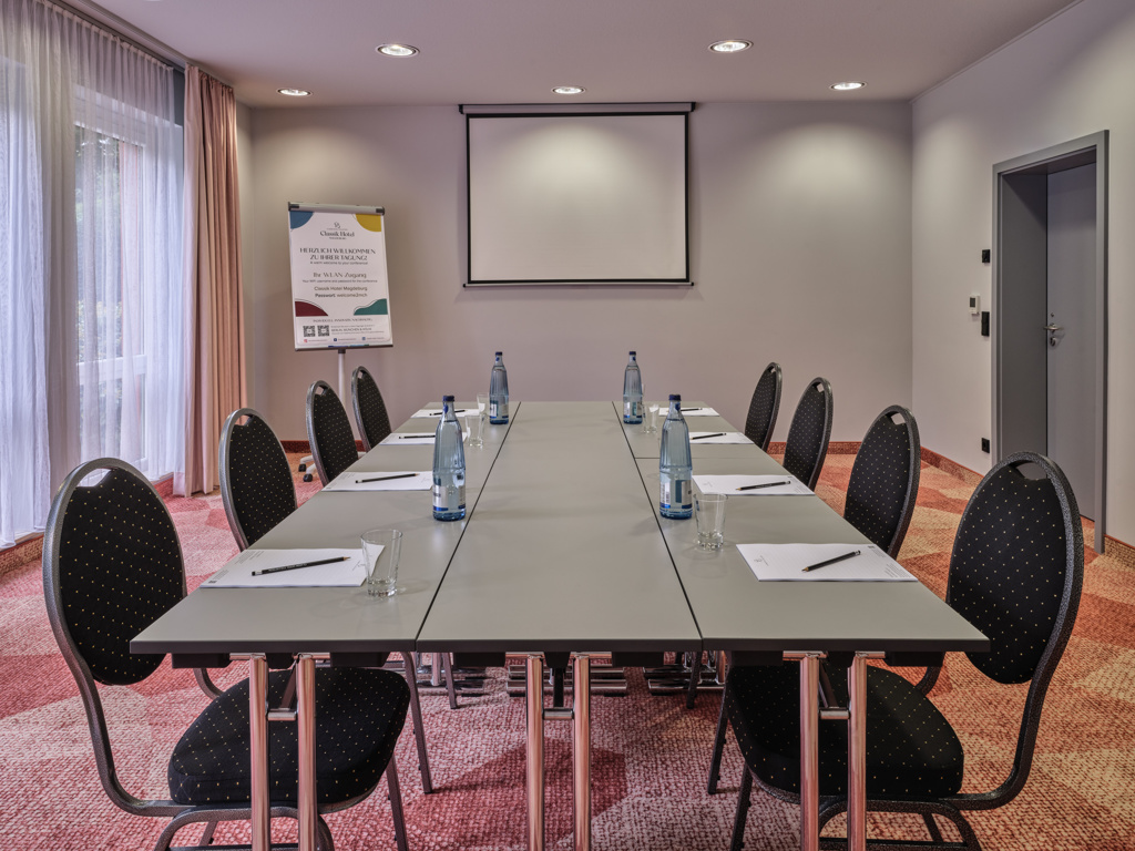 tagungsraum-block-bestuhlung-orangener-teppich-graue-stuehle