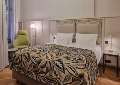 doppelbett-bunte-tagesdecke-gruen-gelber-sessel