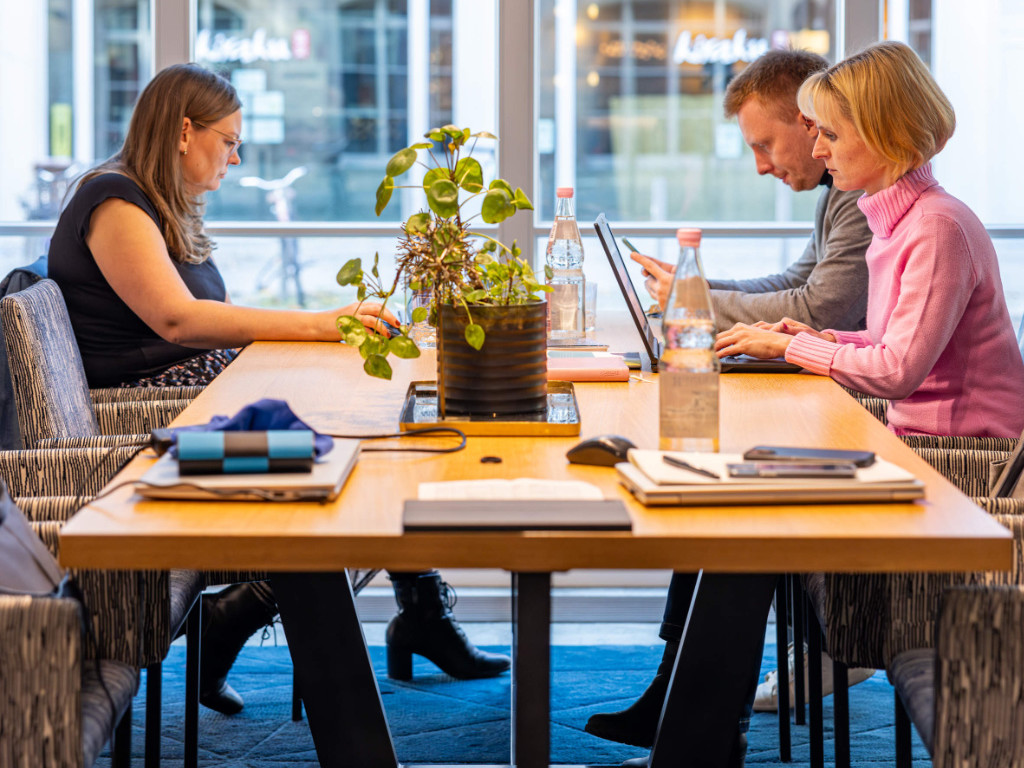 zwei-frauen-und-ein-mann-sitze-an-einem-tisch-und-arbeiten