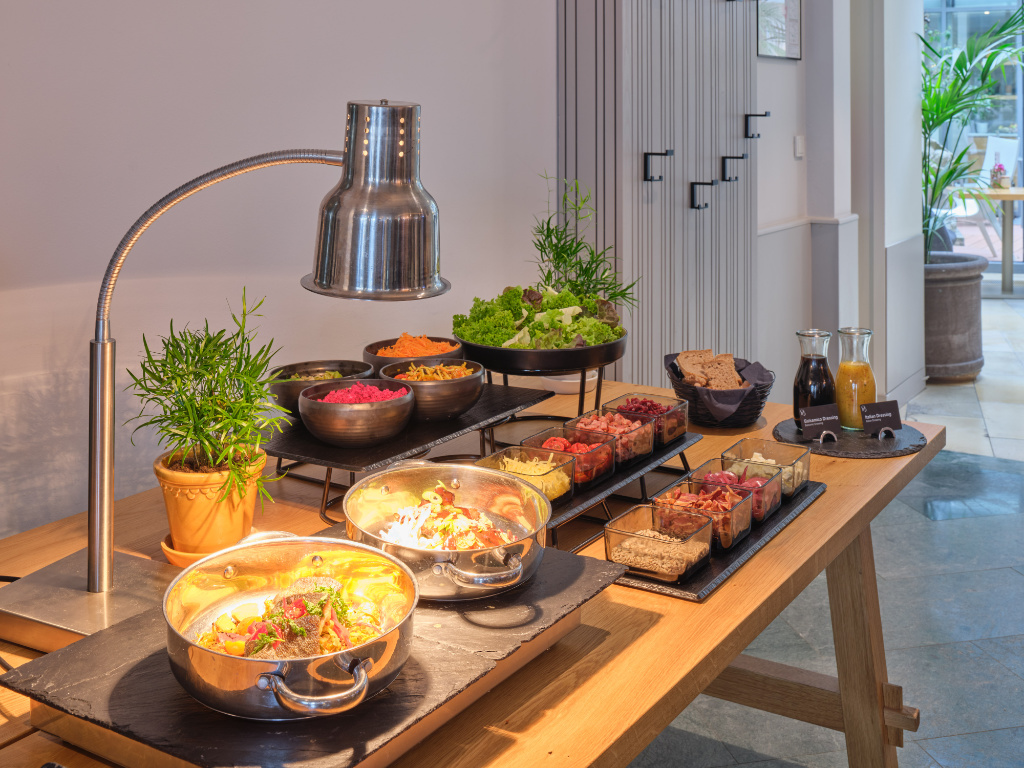 Mittagsbuffet der UNA Tagesbar in Berlin-Mitte mit warmen Speisen, Salatbar, Toppings und Dressings