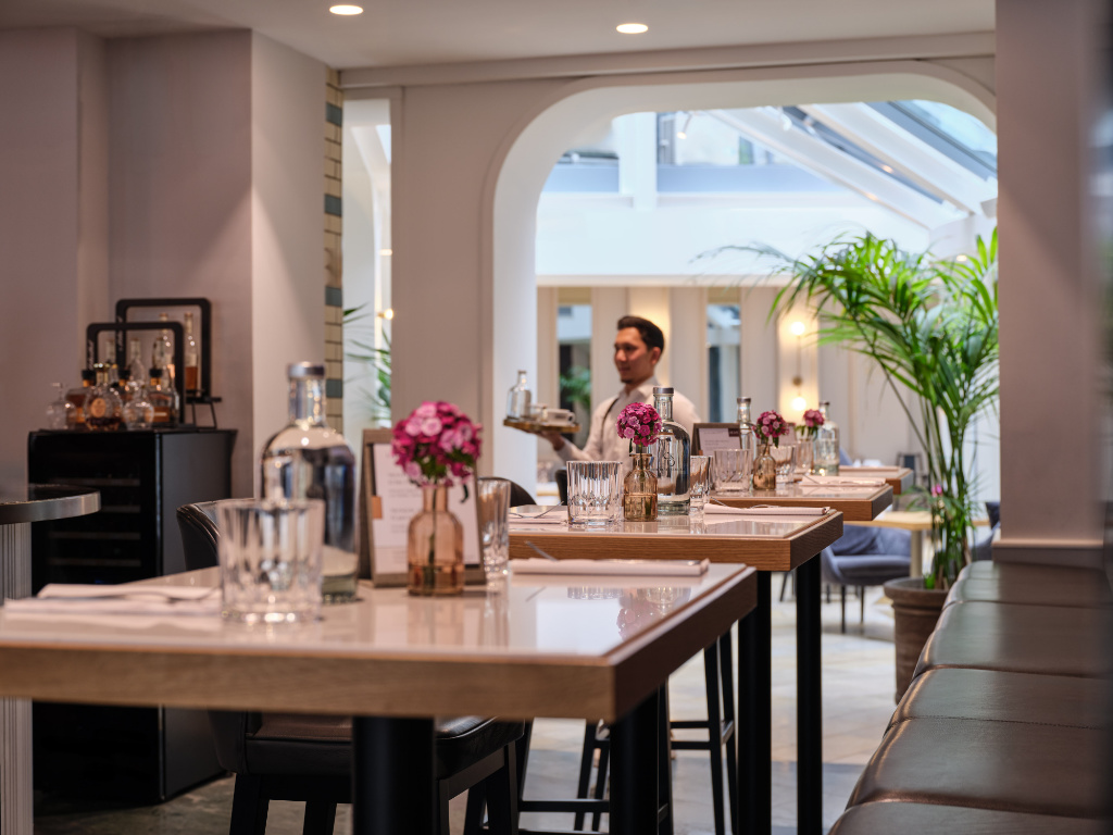 Stehtische mit Blumendekoration in der UNA Tagesbar Berlin-Mitte