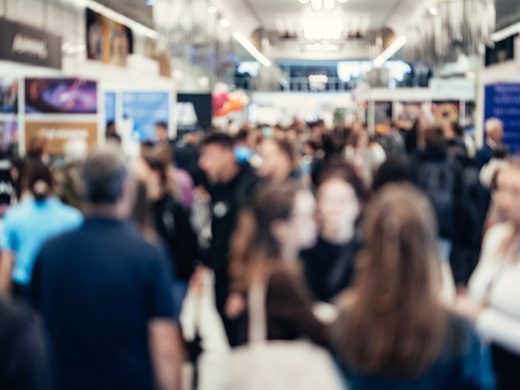 Unscharfes Bild von einer Ausstellung mit vielen Menschen